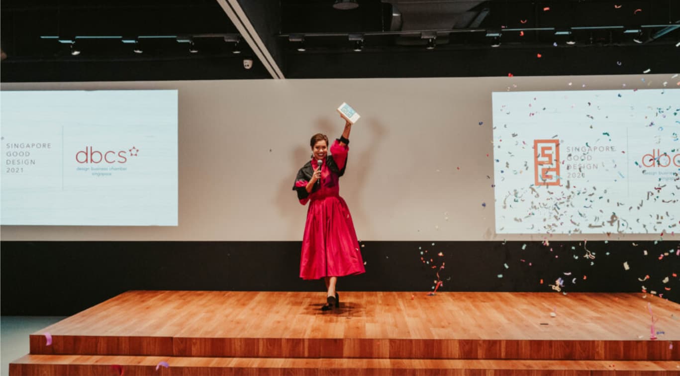 Nikki wearing red dresses on stage with confetti popping